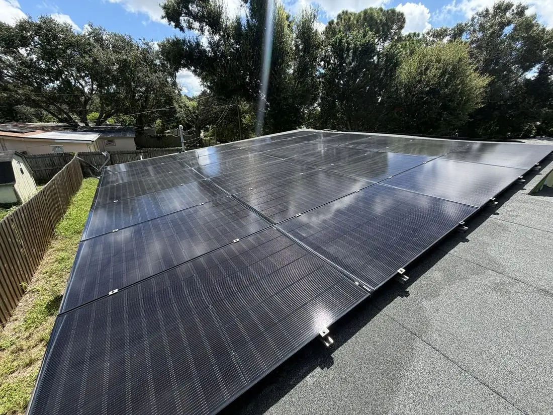 Large clean solar array reflecting sky and trees