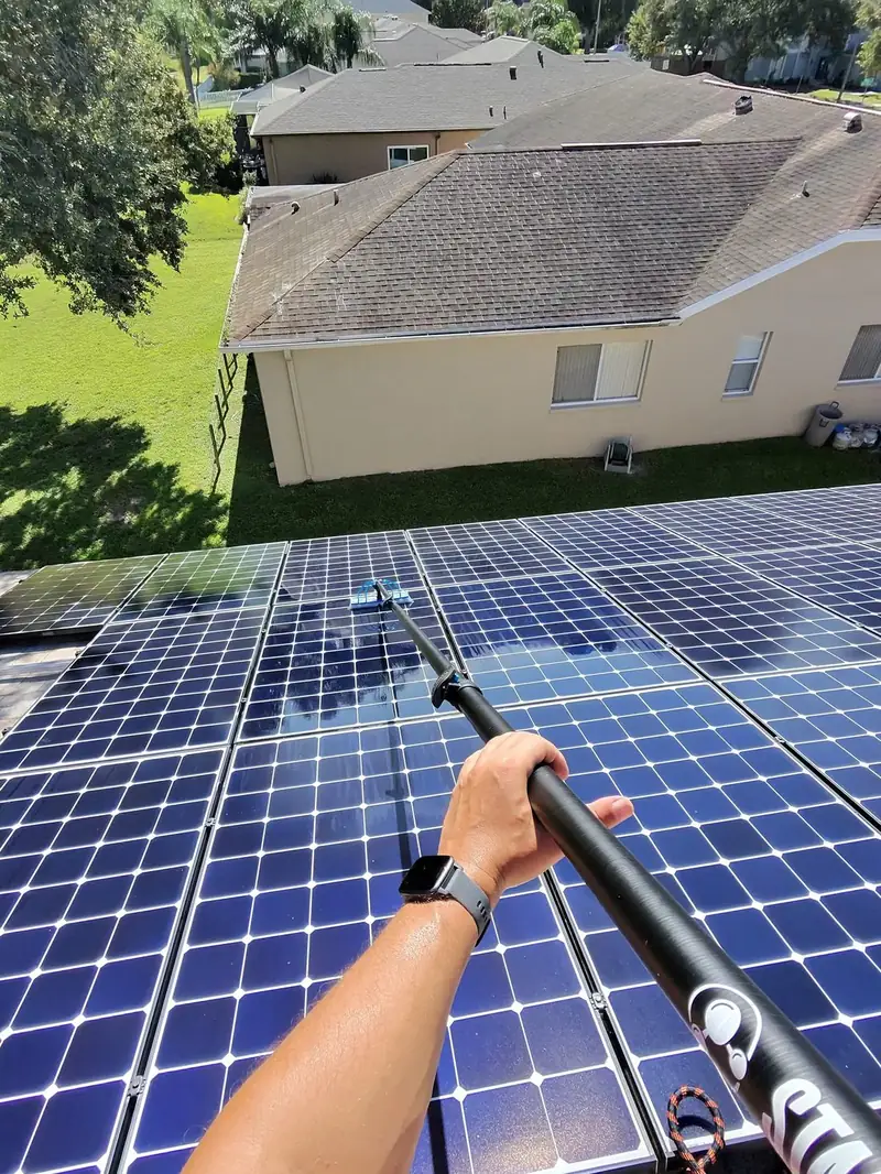 SevenfoldFL technician cleaning solar panels with a water-fed pole